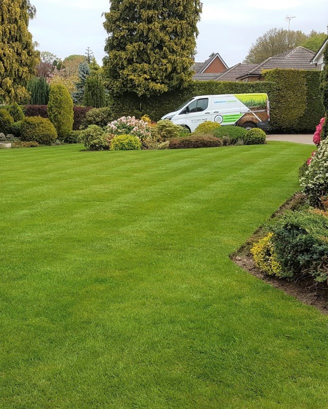 Green and stripped lawn with van